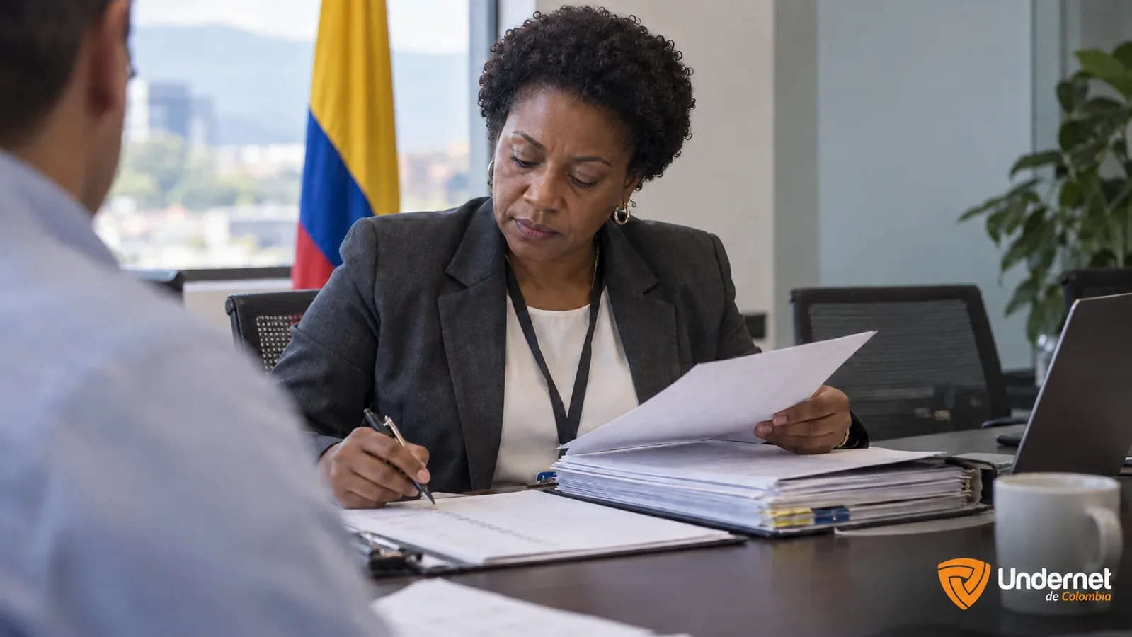 Auditora revisando carpetas y una lista de verificación en una sala de reuniones de una entidad pública