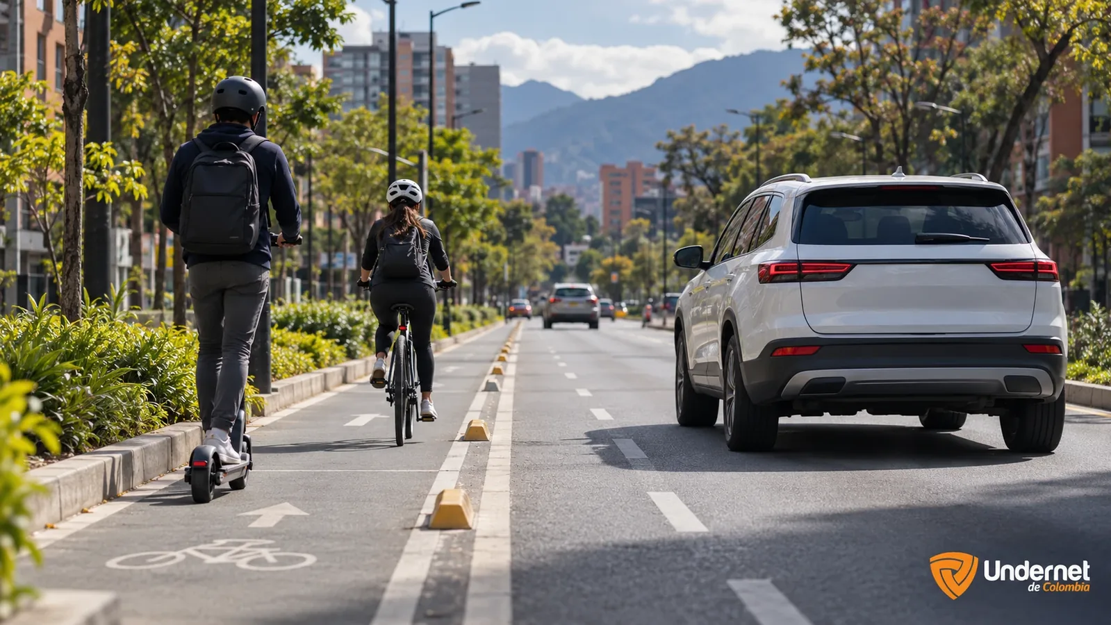 Camioneta que adelanta con amplia distancia a un ciclista y a un usuario de patineta eléctrica en una calle urbana