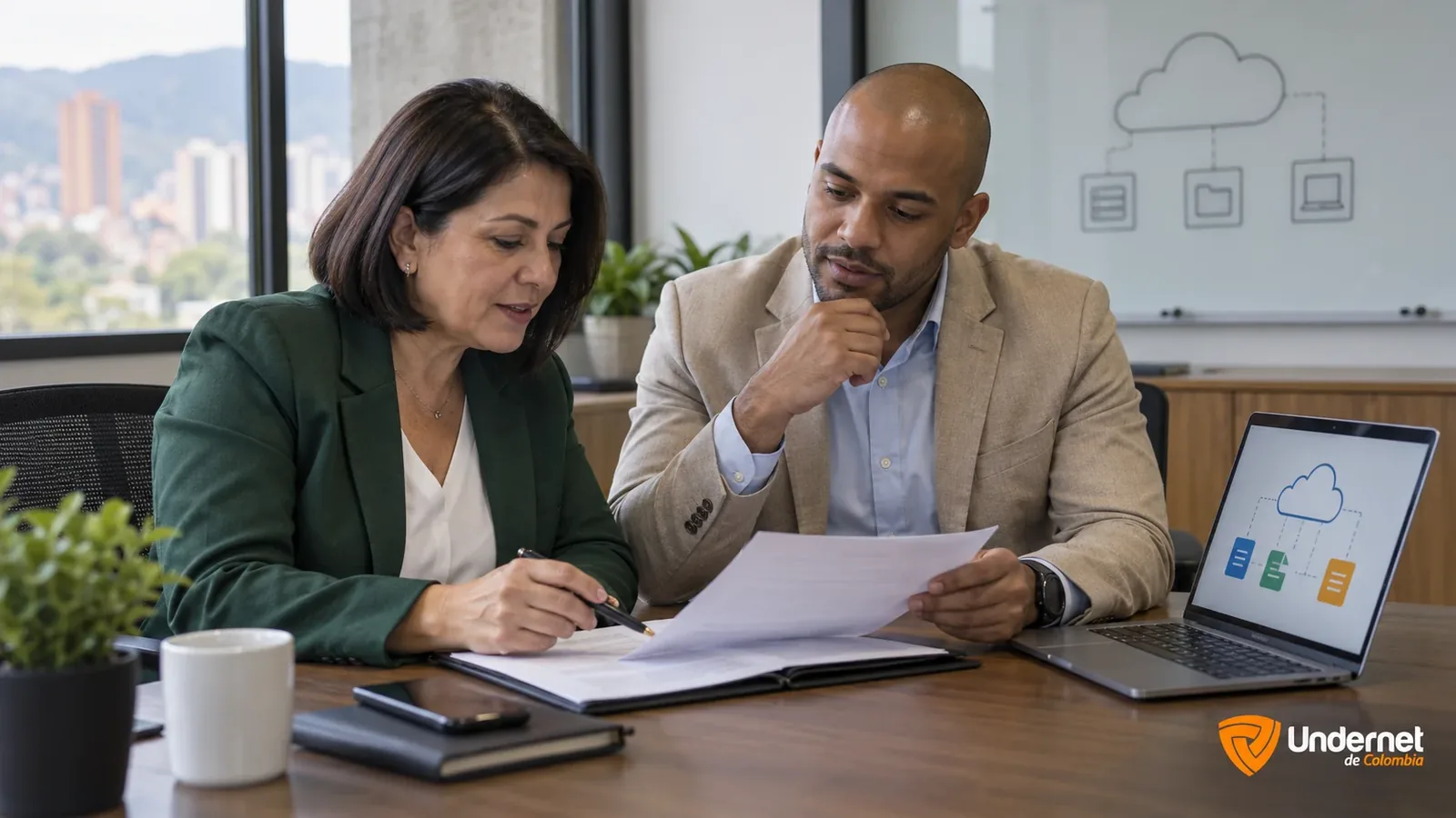 Funcionaria y representante de un proveedor revisando un contrato junto a un diagrama de servicios en la nube
