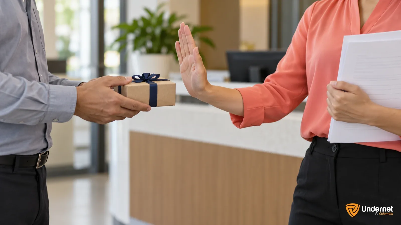 Trabajadora rechaza un regalo mientras sostiene una declaración de intereses.